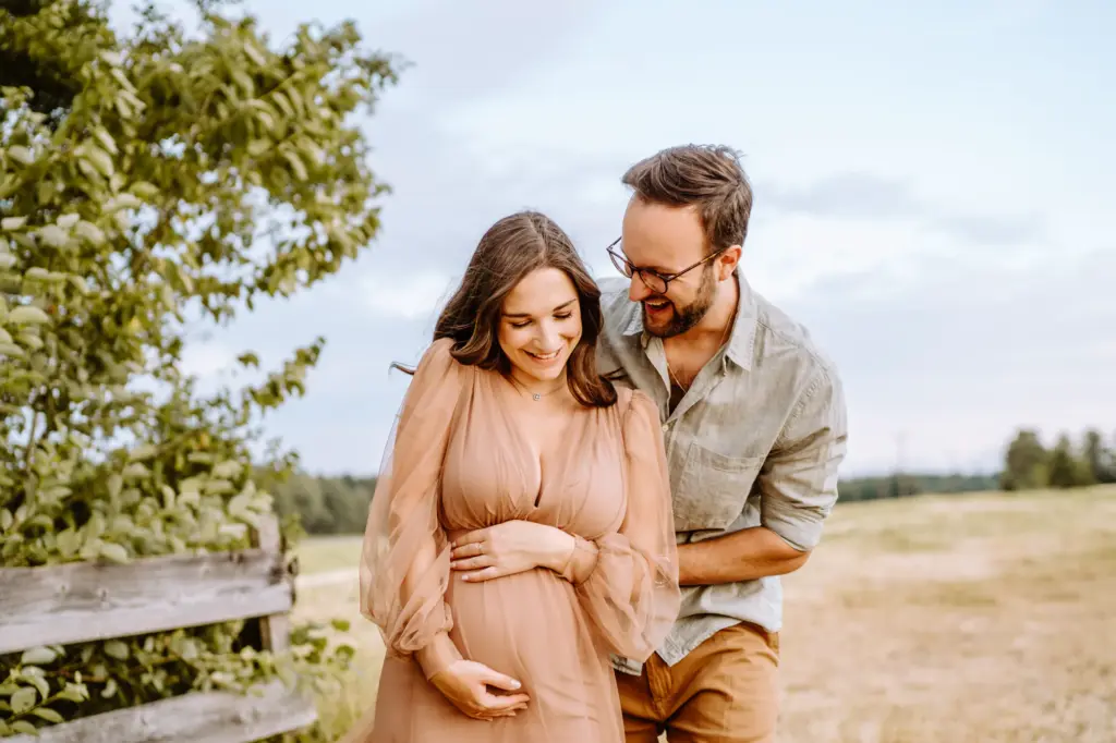 Paar umarmt sich, Babybauch im Fokus, Babybauchfotos am Starnberger See