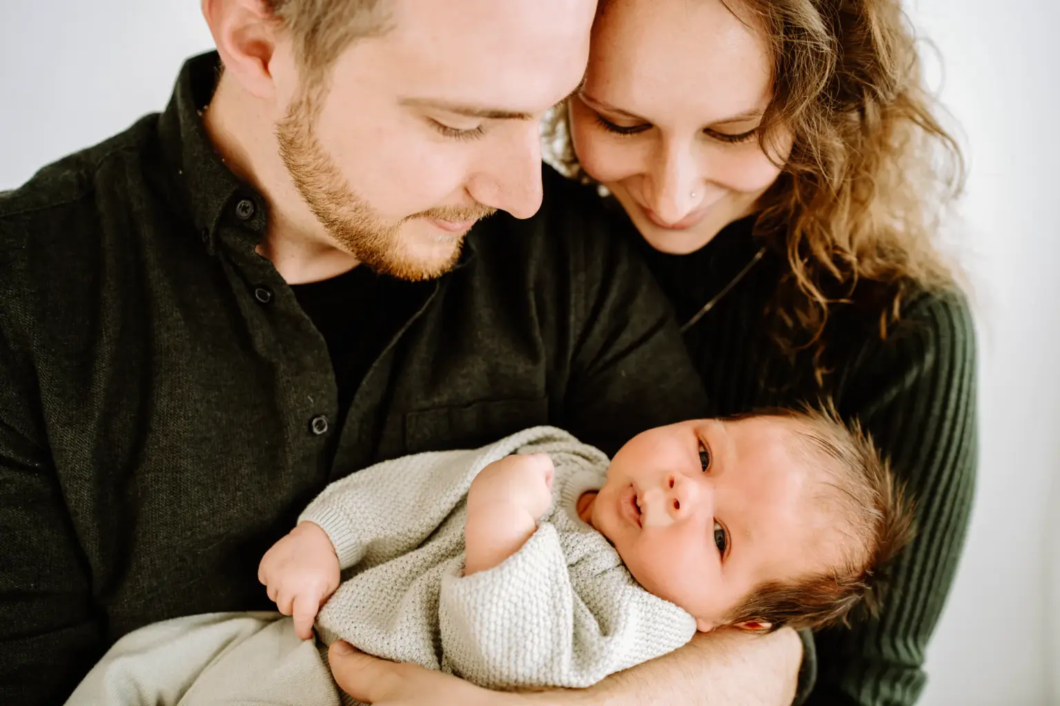 Familie zu dritt vor weißem Hintergrund, zeitloses Newborn Familienbild