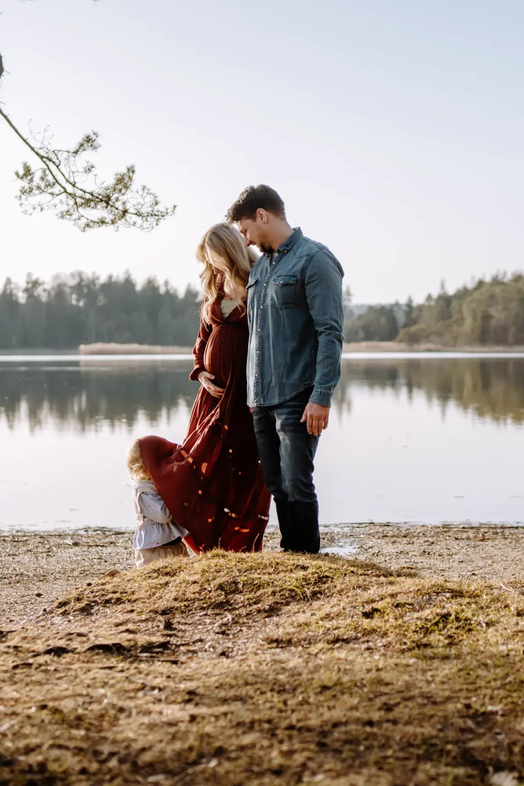 Ungestellte Babybauchfotos zusammen mit der Tochter an einem See in der Nähe von Weilheim